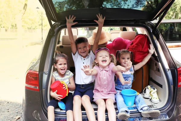 Счастливые дети сидят на багажнике — стоковое фото