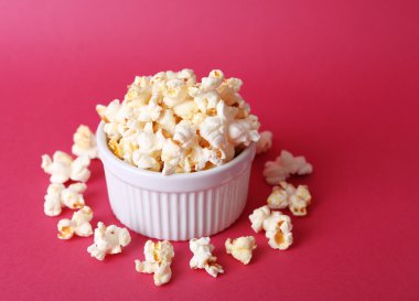 Pembe bir arka plan üzerinde tuzlu popcorn