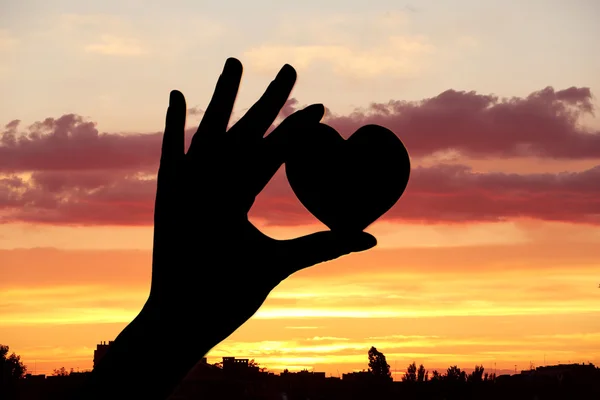 Silhouettes of hand with heart — Stock Photo, Image