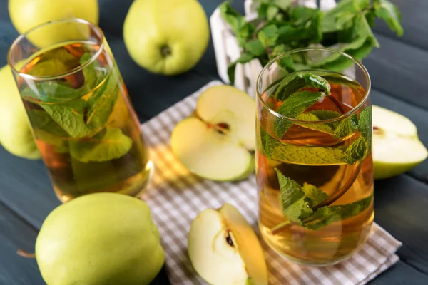 Copos de suco de maçã com frutas e hortelã fresca na mesa de perto — Fotografia de Stock