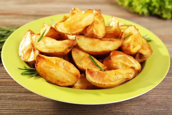 Cunhas de batata assadas na mesa de madeira, close-up — Fotografia de Stock