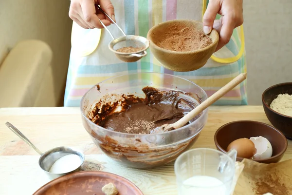 Mulher preparando massa para torta de chocolate na mesa de perto — Fotografia de Stock