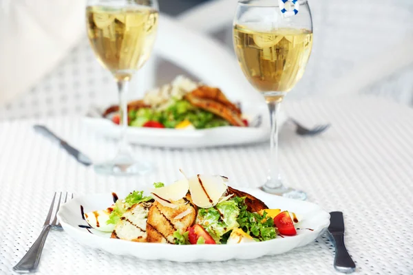 Salada saborosa com vinho na mesa branca servida — Fotografia de Stock