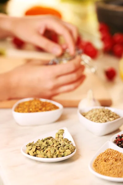 Variedad de especias en recipientes cerámicos en la mesa de la cocina — Foto de Stock