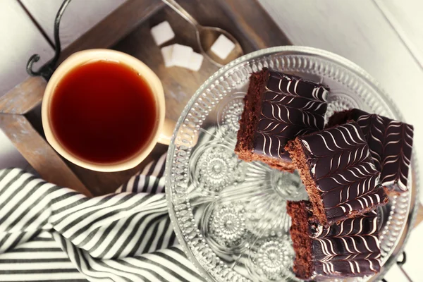 Served table with a cup of tea and chocolate cakes close-up — Stock Photo, Image