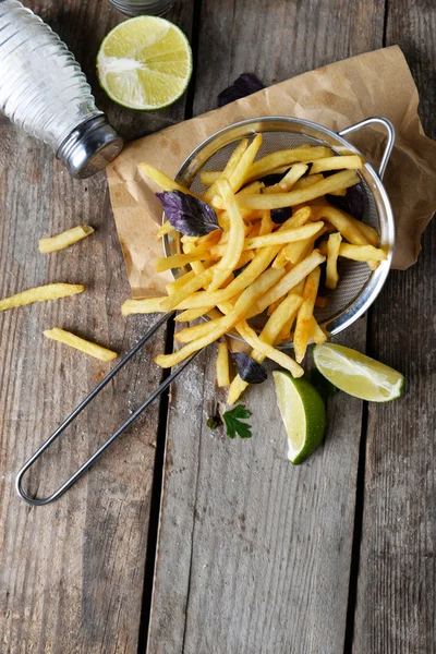 Batatas fritas francesas em escorredor de metal — Fotografia de Stock