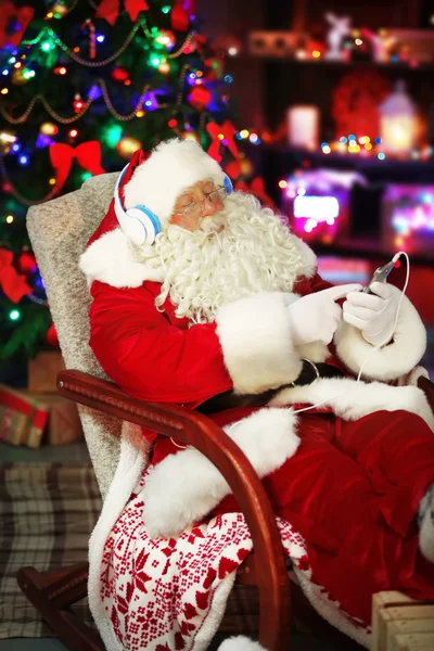 Santa Claus zitten met koptelefoon — Stockfoto
