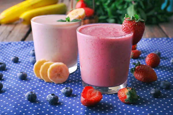 Sebze ve meyveler, mavi masa örtüsü arka plan üzerinde taze soğuk yüzlü bardak