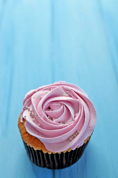 Smakelijke cupcake op houten achtergrond — Stockfoto