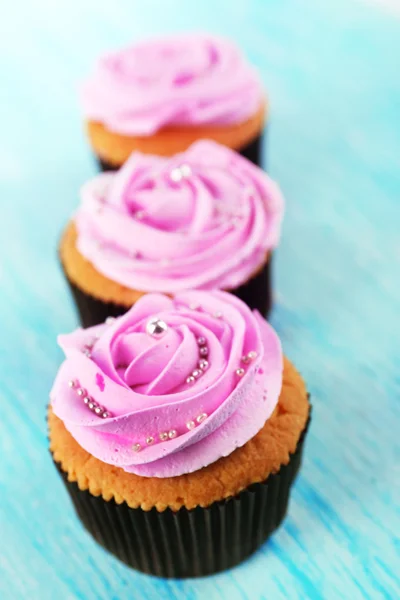 Cupcakes saborosos no fundo de madeira — Fotografia de Stock