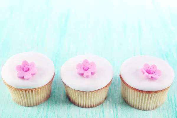 Cupcakes saborosos no fundo de madeira — Fotografia de Stock