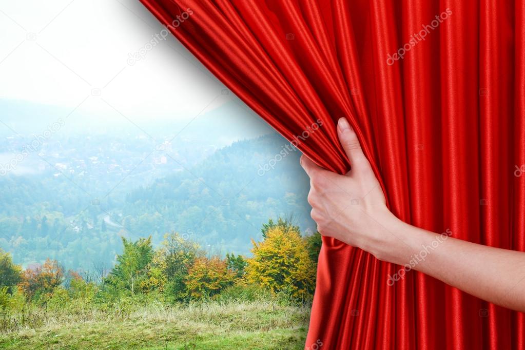 hand opens red curtain 