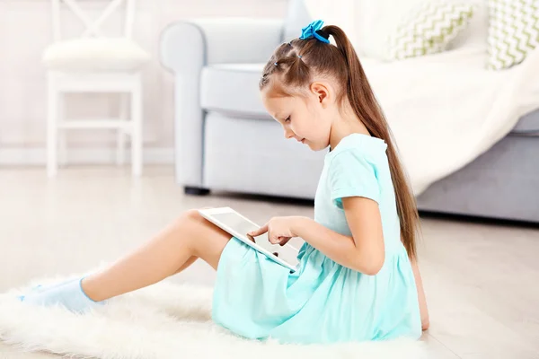 Kleines süßes Mädchen mit digitalem Tablet — Stockfoto