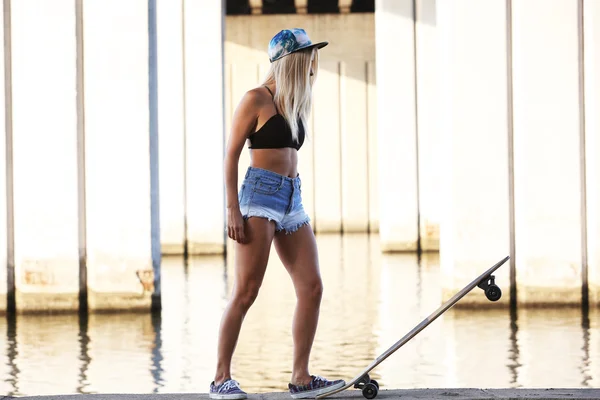 Junge Frau mit Skateboard — Stockfoto