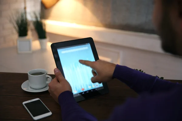 Młody człowiek za pomocą jego komputera typu tablet, z bliska — Zdjęcie stockowe