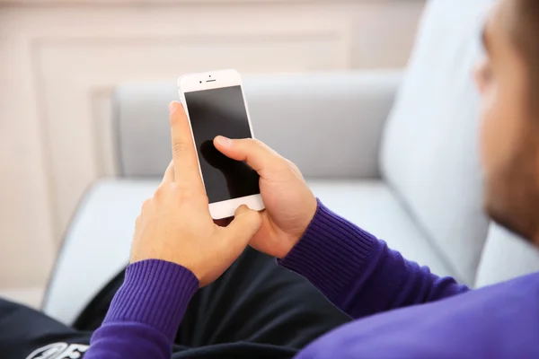 Joven usando su teléfono inteligente, de cerca — Foto de Stock