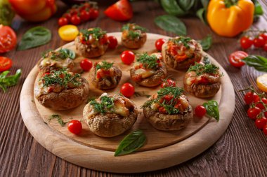 Ahşap bir tablet ile masaya sebze ve mantar dolması