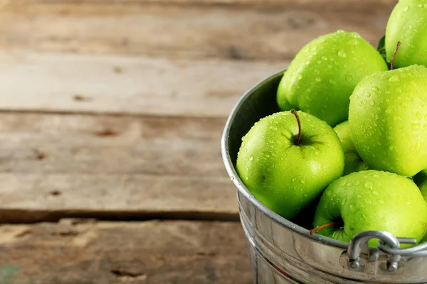 Manzana verde madura en cubo de metal sobre mesa de madera de cerca — Foto de Stock