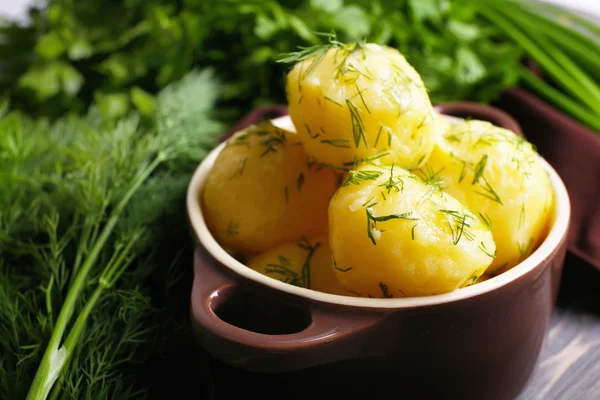 Kokt potatis med greener i skål på bordet på nära håll — Stockfoto