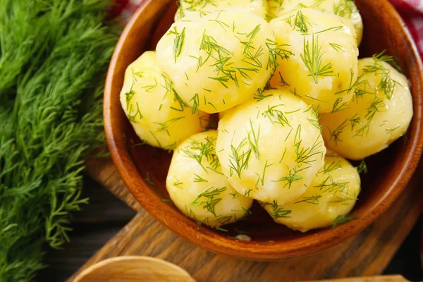 Kokt potatis med greener i skål på bordet på nära håll — Stockfoto