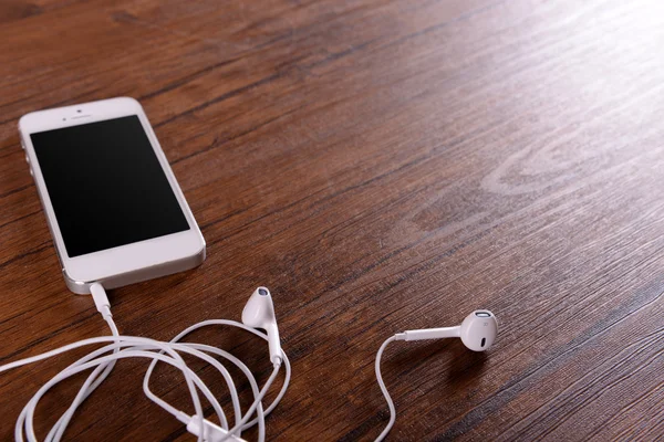 Celular branco com fones de ouvido — Fotografia de Stock