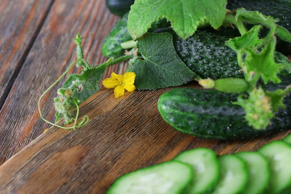 Komkommers op houten achtergrond, close-up — Stockfoto