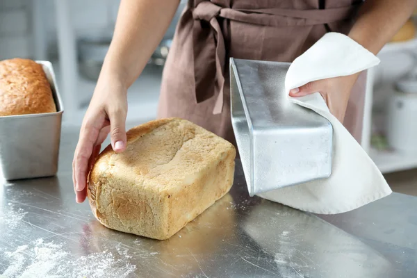 Panadero con pan recién horneado en cocina de panadería — Foto de Stock