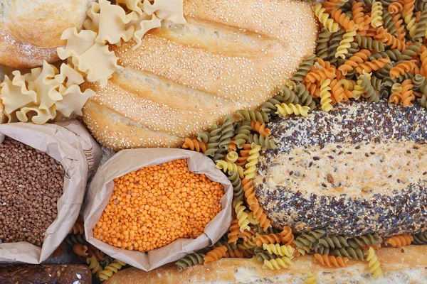 Pães mistos, macarrão e grãos de fundo, close-up — Fotografia de Stock