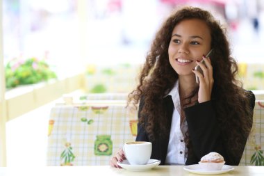 Restoranda cellphone tarafından konuşan genç gülümseyen kadın