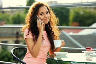 Cellphone tarafından konuşma ve kahve içme genç ve güzel kadın portresi kapatın
