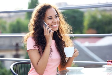 Cellphone tarafından konuşma ve kahve içme genç ve güzel kadın portresi kapatın