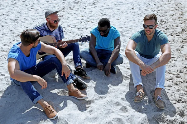 Men sitting on sand — Stock Photo, Image