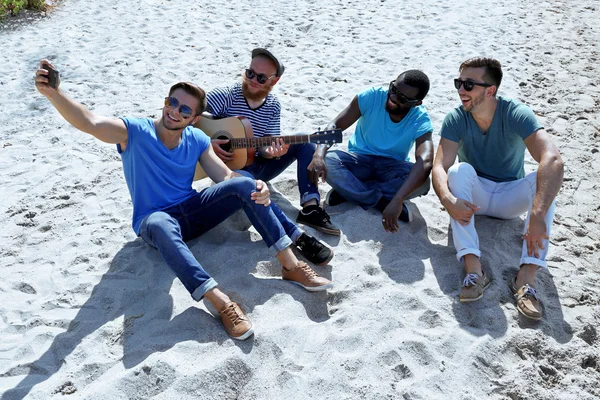 kum üzerine oturan adam