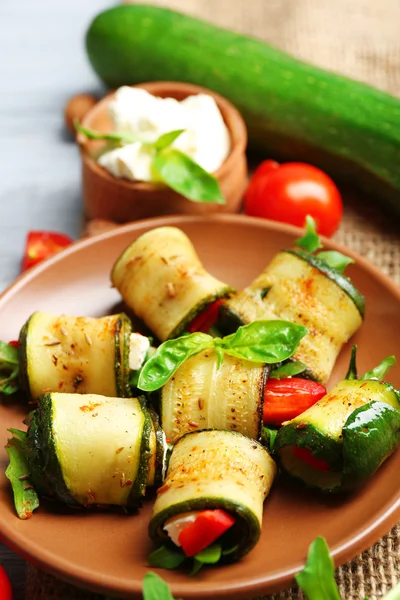 Salat mit Rucola und Zucchini-Rollen auf Teller, auf Tischhintergrund — Stockfoto