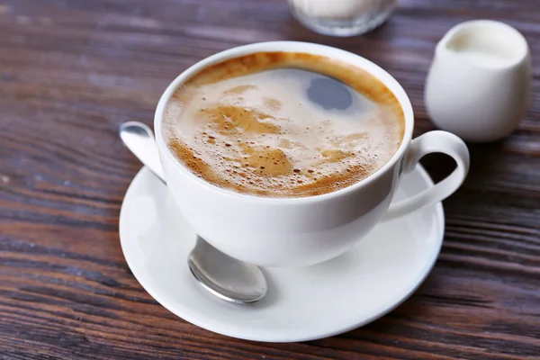 Šálek kávy se smetanou na dřevěném pozadí — Stock fotografie