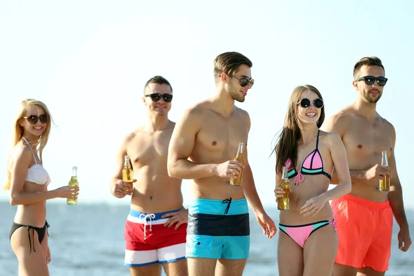 Happy přátelé pít pivo na pláži — Stock fotografie