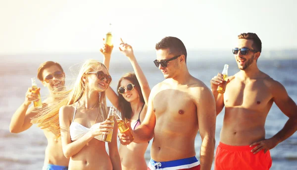 Happy vrienden drinken bier op strand — Stockfoto