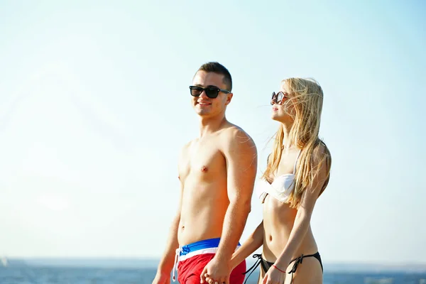 Felice coppia che si tiene per mano in spiaggia — Foto Stock