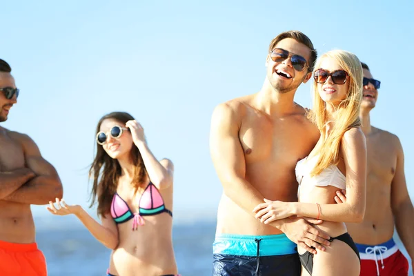 Coppia felice e amici rilassarsi in spiaggia — Foto Stock