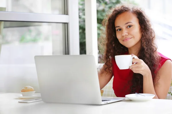 Giovane bella donna d'affari con computer portatile nel ristorante bere caffè, primo piano — Foto Stock