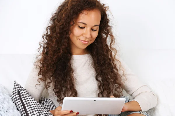 Bella donna seduta sul divano con tablet bianco — Foto Stock