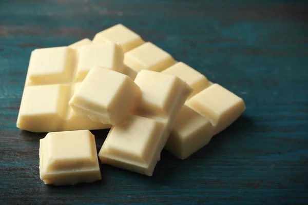 Witte chocolade stukjes op een houten achtergrond kleur — Stockfoto