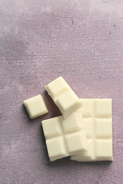 Renk ahşap arka plan üzerine beyaz çikolata parçaları — Stok fotoğraf