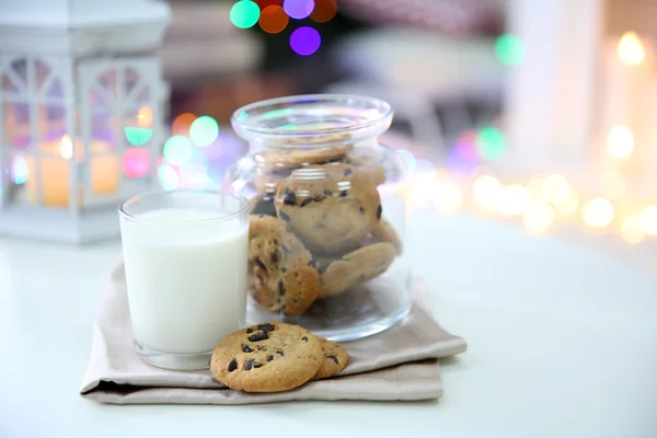 Galletas de Navidad y vaso de leche en la mesa en casa — Foto de Stock