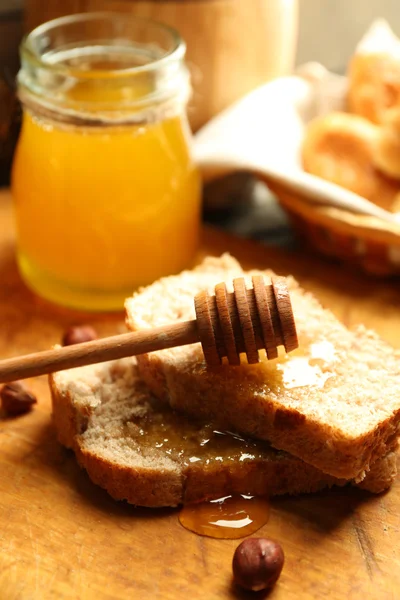 Frisches Brot mit Honig auf Holzgrund — Stockfoto