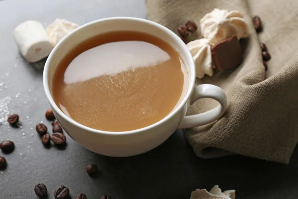 Cangkir kopi dan permen di latar belakang kayu hitam — Stok Foto