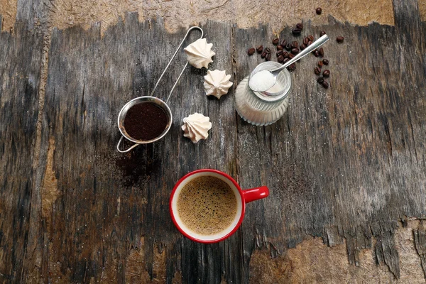 Secangkir kopi dengan permen di latar belakang kayu — Stok Foto