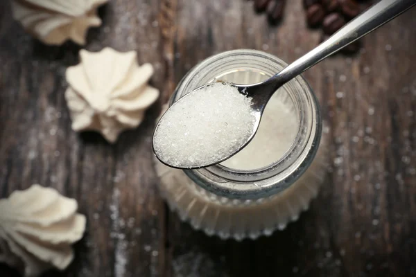 Sugar bowl and kisses on wooden background — Stock Photo, Image