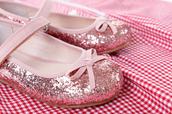 Glänzend rosa Schuhe auf rotem kariertem Hemd Hintergrund, Nahaufnahme — Stockfoto