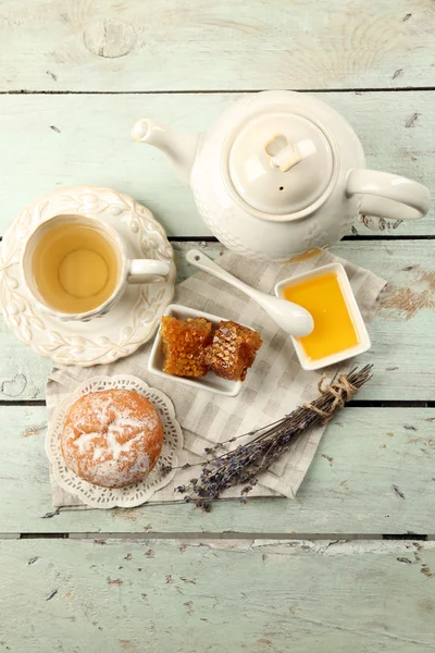 Медовые соты, миска с медом, чайник на цветном деревянном фоне — стоковое фото